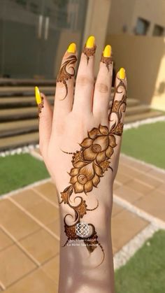 a woman's hand with hennap and yellow nail polishes on it