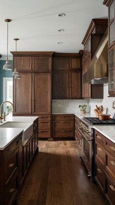 a large kitchen with wooden cabinets and white counter tops, along with hardwood flooring