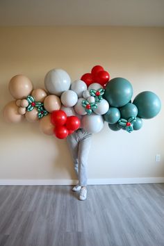 a person standing in front of a wall with many balloons attached to the back of their head