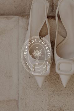 a pair of white shoes sitting on top of a stone floor next to a wall