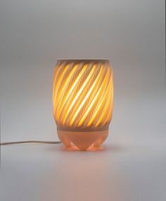 a light that is turned on and sitting on a white surface with a cord attached to it