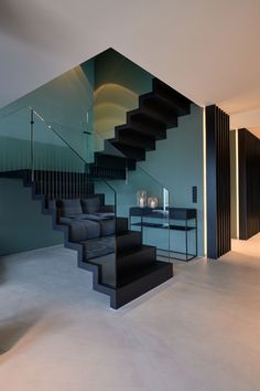 a black and white stair case next to a table with two wine glasses on it