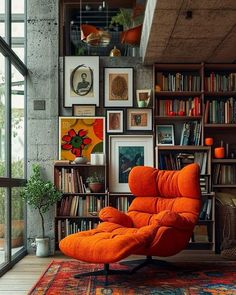 an orange chair sitting in front of a bookshelf filled with lots of books