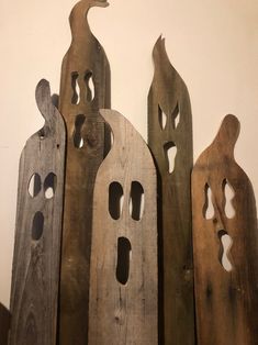 three wooden sculptures with holes in them on the wall