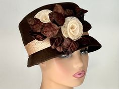 The featured hat is a brown wool felt winter hat.  An ivory sinamay band goes around the rise of the hat.  A bunch of brown velvet leaves sit on the side of the hat. Two ivory rose sinamay buds sits amidst the leaves. This hat is classy, well made and sophisticated. This hat can be worn as a winter Church Hat, a Wedding Party Hat, a Tea Party hat, a Downton Abbey  hat, and any other special occasion. A wool winter hat for warmth and style together. Brim: 2" Rise: 4" Size:22" This hat is made fro Wool Winter, Tea Party Hats, Church Hats, Fancy Hats, Cloche Hat, 1920s Fashion, Sun Hats, Party Hats, Hat Fashion