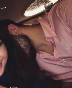 a woman laying down next to a man in a pink shirt