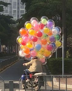 a person on a motorcycle with balloons attached to the back