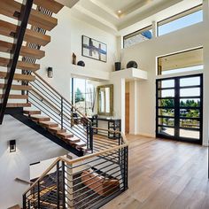 an open floor plan with stairs and windows