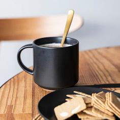 a cup of coffee and some crackers on a table