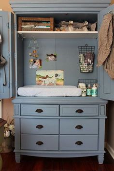 a baby's crib in the corner of a room with blue cupboards