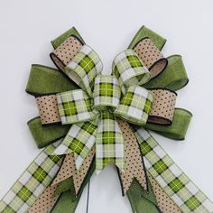 a green and white checkered bow with polka dots on the front, attached to a wall