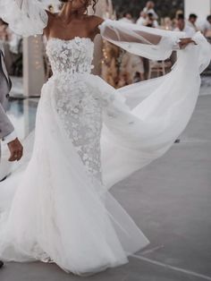 a bride and groom walking down the street