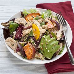 a salad with chicken, lettuce, tomatoes and other vegetables on a white plate