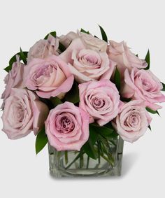 a vase filled with pink roses on top of a table