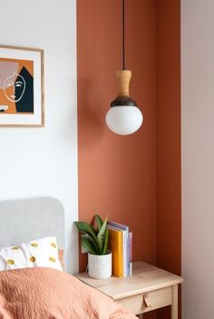 a bedroom with an orange wall and white bed