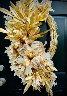 a wreath is hanging on the front door with dried flowers and leaves in it's center