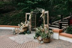 an outdoor ceremony setup with flowers and greenery