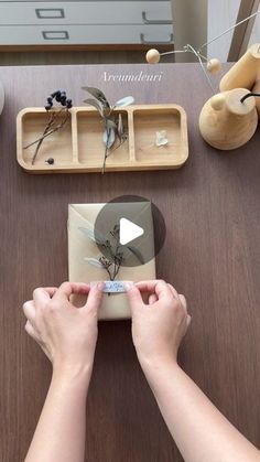 two hands are holding an object on top of a table