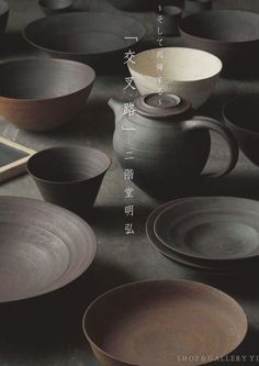 there are many bowls and cups on the table together with chinese characters in the background