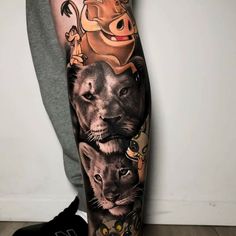 a man's leg with tattoos on it, including lions and other animals in the background