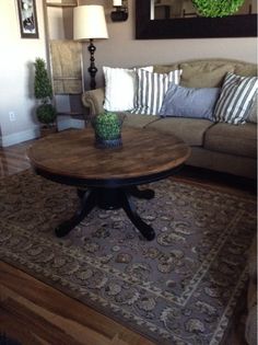 a living room with a couch, table and mirror in the corner on the wall