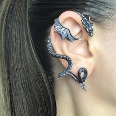 Unleash your inner mythical creature with our stunning Single Dragon Wing Ear Cuff! This captivating piece is sure to turn heads and ignite conversations. Crafted with intricate detail, this gothic dragon earring wrap features a beautifully designed dragon wing that elegantly hugs your ear. Made from high-quality materials, it's lightweight and comfortable, perfect for everyday wear or special occasions. This unique dragon jewelry adds a touch of fantasy to your style, making it a must-have acce Ušný Piercing, Dragon Ear Cuffs, ماثيو ماكونهي, Edgy Jewelry, Dragon Earrings, Gothic Earrings, Magical Jewelry, Dragon Jewelry, Vintage Punk