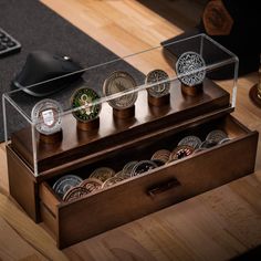 a wooden box filled with coins on top of a table