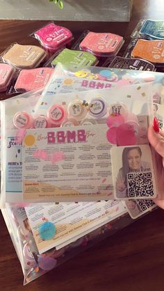 a person is holding up a package with some stickers on it and other items in the background