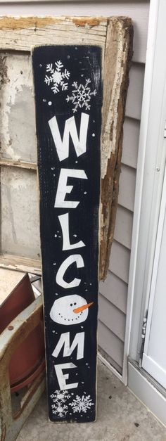 a wooden sign that says welcome with a snowman on the bottom and words written in white