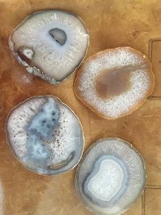 three oysters are sitting on a table with their shells covered in white and brown substance