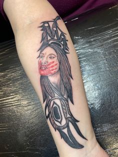 a woman's arm with a tattoo on it that has an image of a face