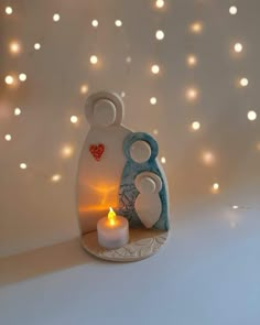 a candle holder with a couple in it and some lights on the wall behind it