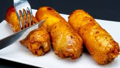 some food is on a white plate with a fork and knife next to it, ready to be eaten