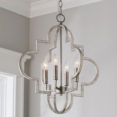 a chandelier with four candles hanging from it