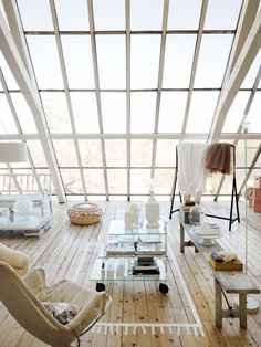 an office with glass walls and lots of furniture in the room, including two desks