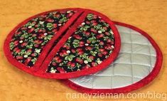 two red and black pot holders on a table