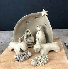 a ceramic figurine of two dogs and a baby in a manger scene