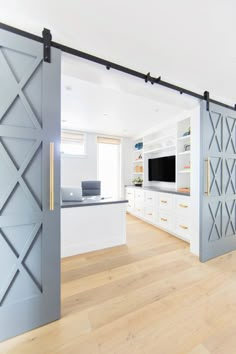 an open door leading to a living room with white cabinets and wood flooring in it