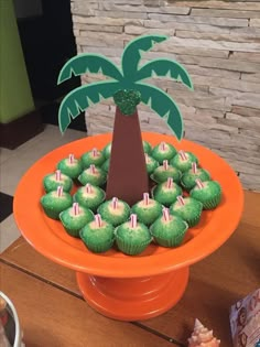 cupcakes are arranged in the shape of a palm tree on an orange plate