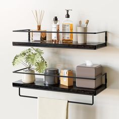 two black shelves with soaps, lotion and other items on them next to a white wall