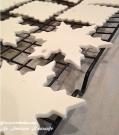 snowflake cookies are cooling on a rack in the shape of an ornament