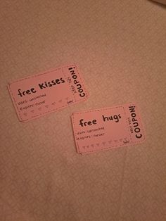 two pink coupons sitting on top of a bed