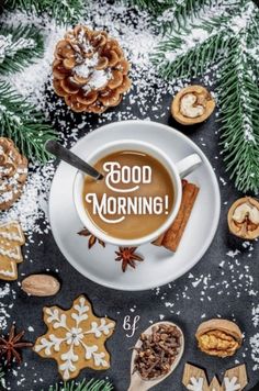 a cup of coffee with the words good morning on it surrounded by cookies and spices