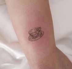 a small tattoo on the leg of a woman's left arm with a hat