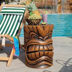 a wooden tiki chair next to a pool with a pineapple in the center