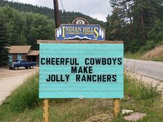 a sign that says cheerful cowboys make jolly ranchers on it in front of a road