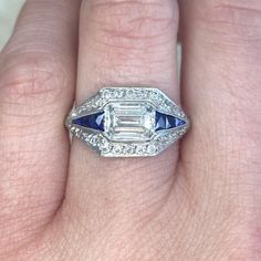 a woman's hand with a diamond and sapphire ring