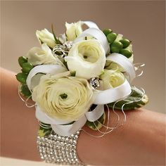 a bridal bouquet on the arm of a woman's hand with white flowers