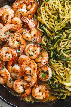 shrimp, pasta and zucchini in a skillet with pesto sauce on the side