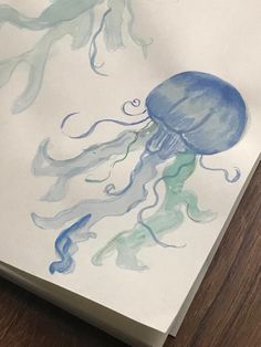 a watercolor drawing of a jellyfish on white paper